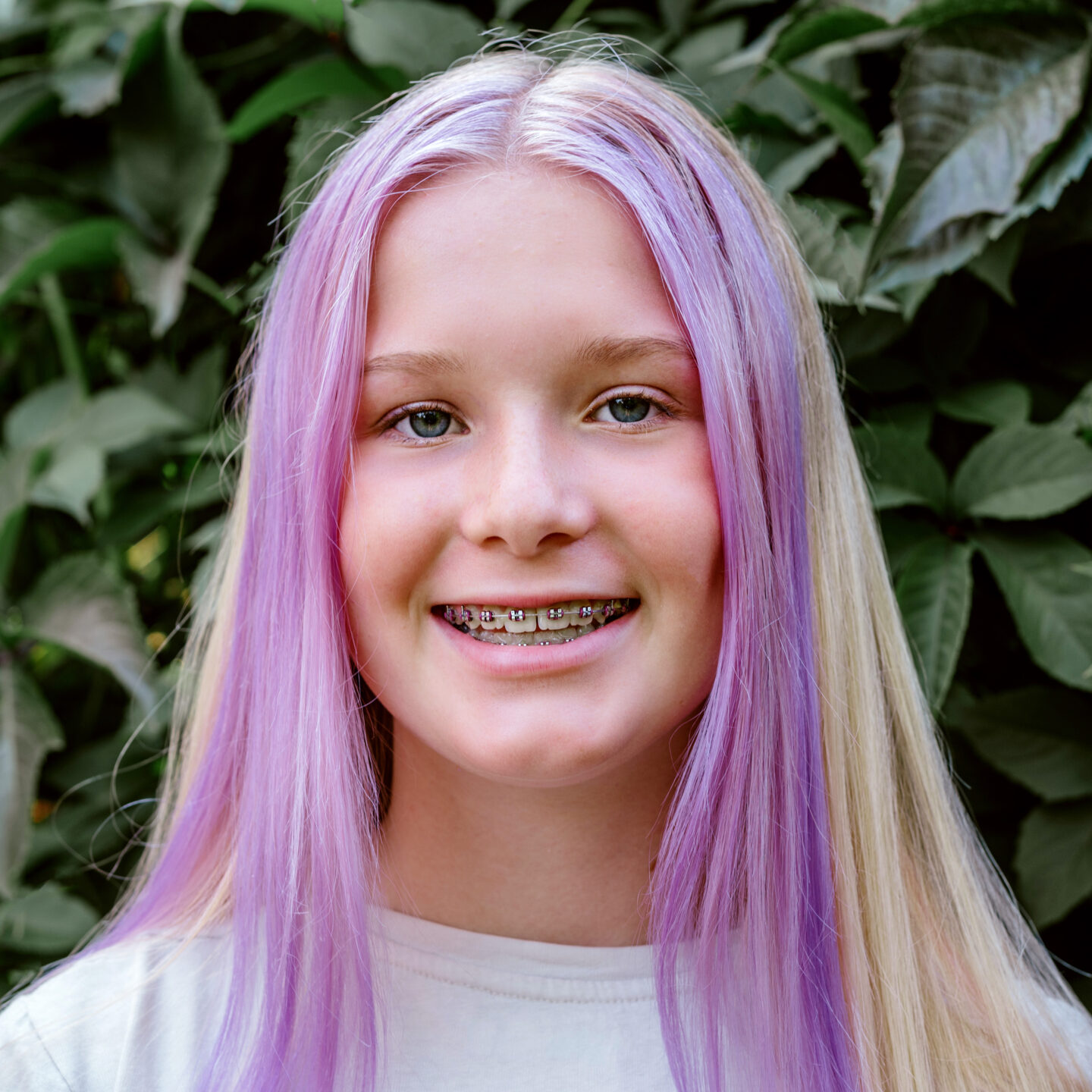 LGBTQ young person with braces smiling.